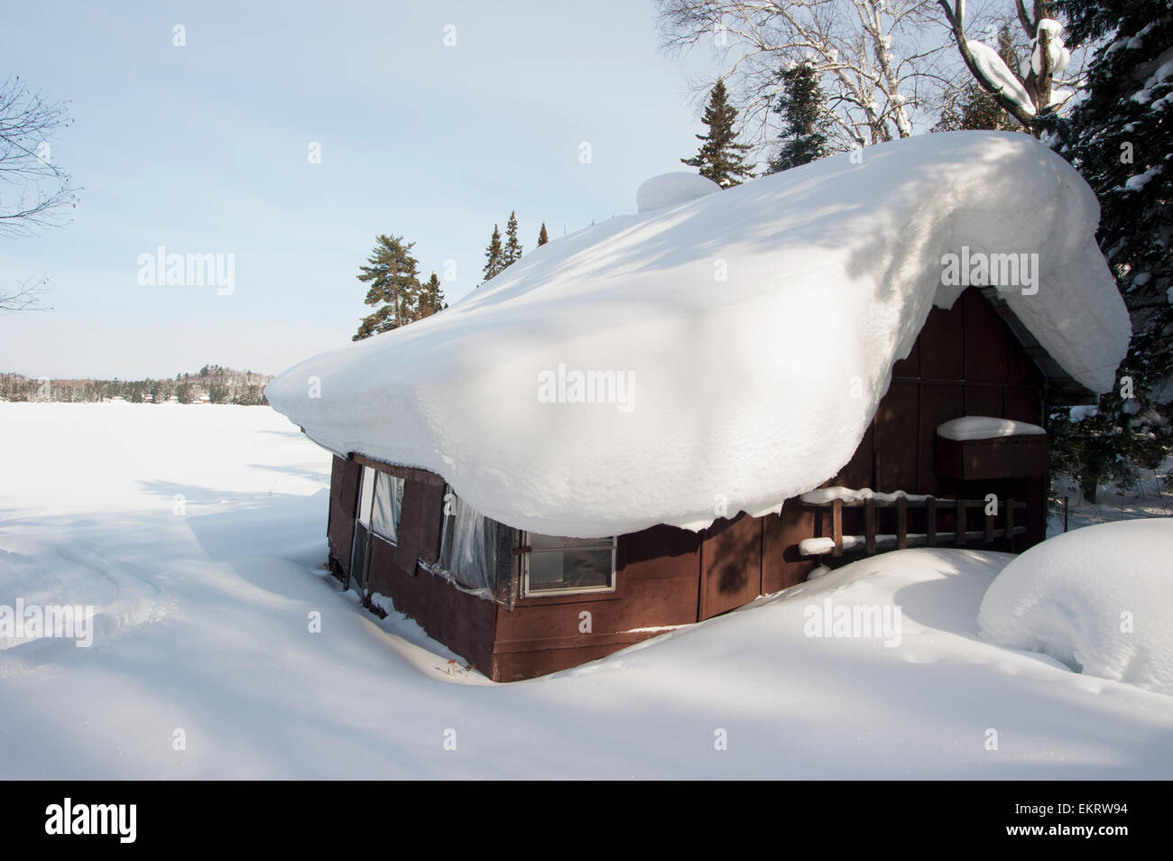 Wildniscamp mit Schnee im Winter in der Nähe von einem zugefrorenen See bedeckt; Ontario, Kanada Stockfoto