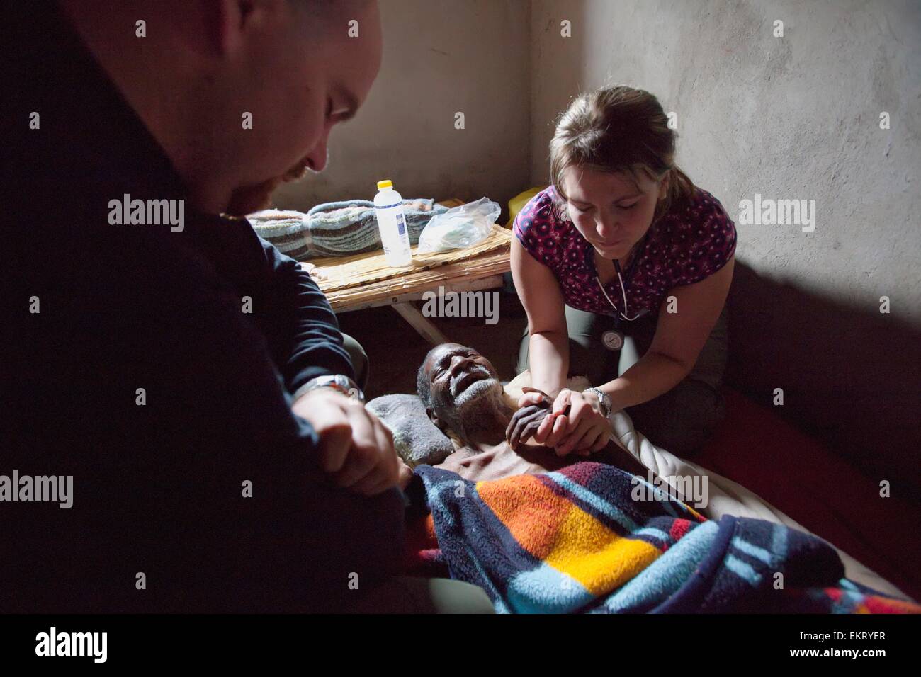 Angehörigen des medizinischen Personals beten über A Mann an Lungenentzündung sterben; Manica, Mosambik, Afrika Stockfoto