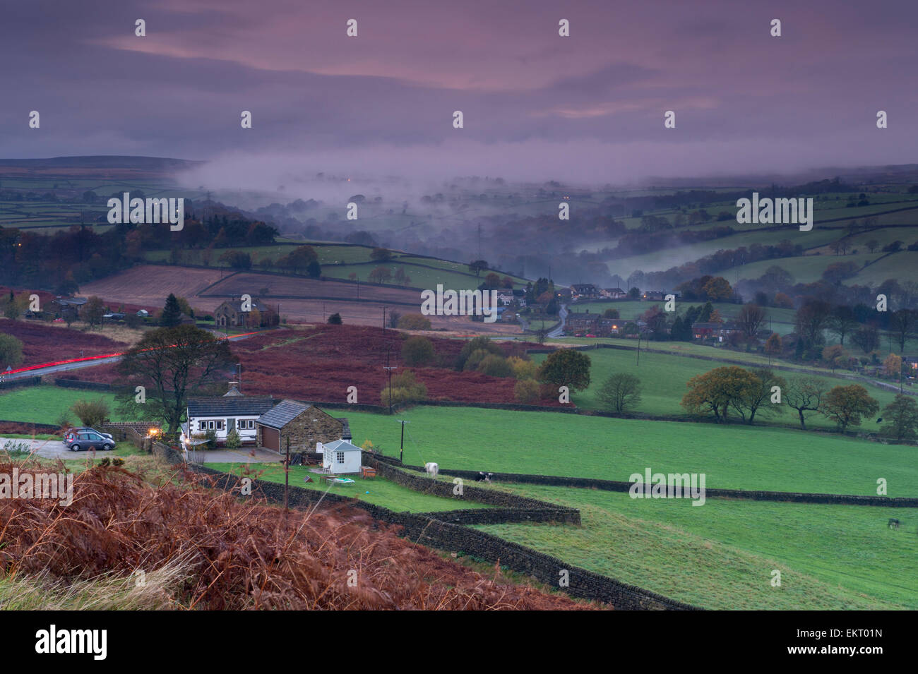 Am Abend Nebel liegt unter auf grünen Wiesen, hügelige Berge & im Tal, gesehen von einem hohen Aussichtspunkt auf Baildon Moor, Yorkshire, England, UK. Stockfoto