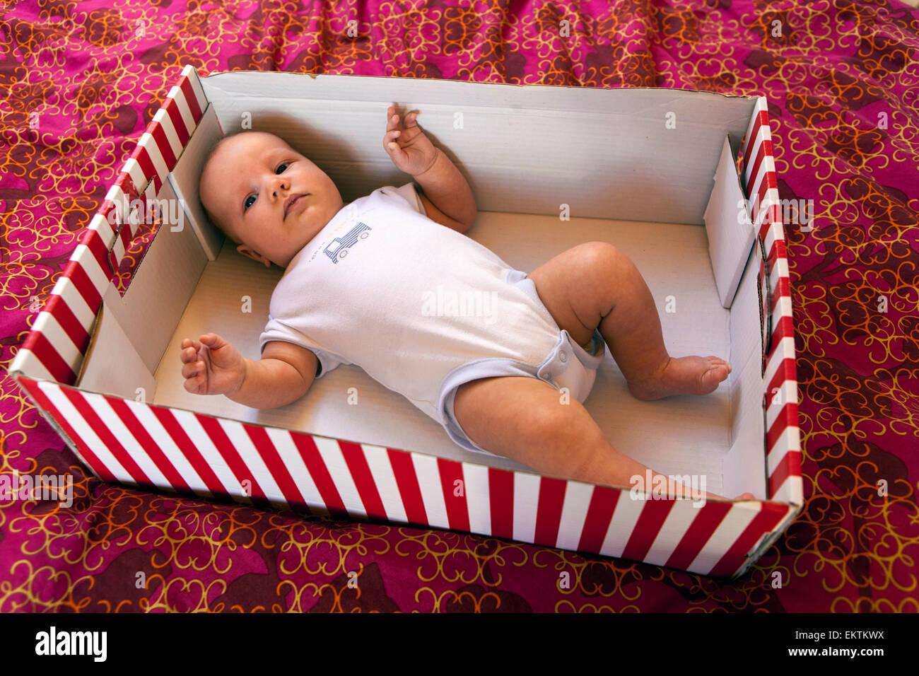 Baby in einem gestreiften Karton, Babybox Stockfoto