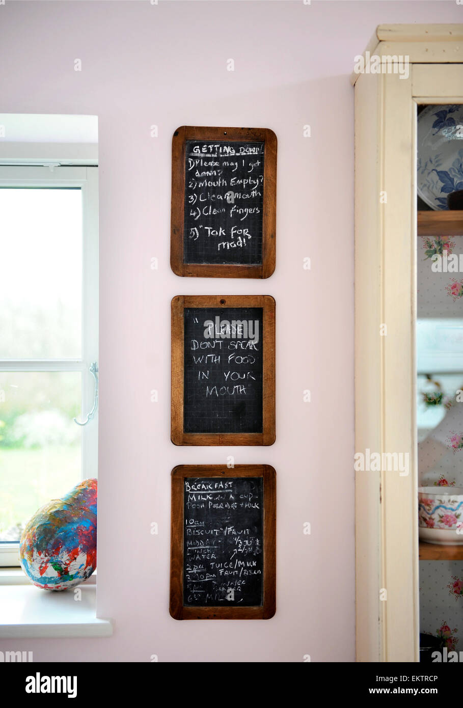 Eine Reihe von Kreidetafeln auf eine Küchenwand mit shopping-Listen, die Memos und in der Hausregel sagen, "Bitte nicht mit Lebensmitteln in yo sprechen Stockfoto