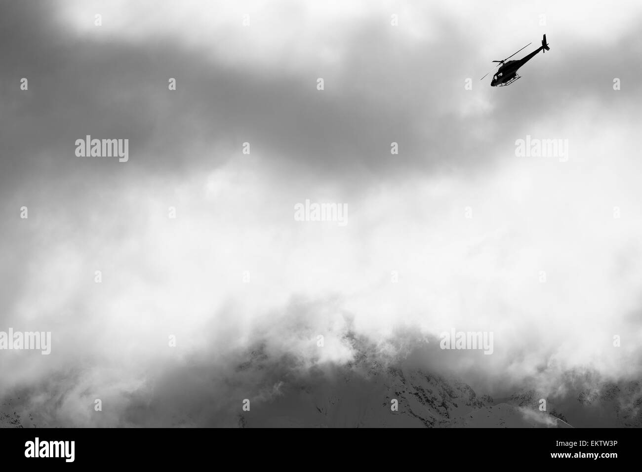 Heli-Ski-Hubschrauber fliegen unter Nebel und Wolken, Neuseeland Stockfoto