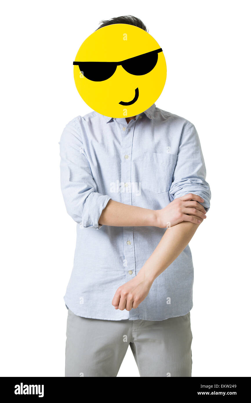 Junger Mann mit einem cool Smiley-Gesicht vor seinem Gesicht Stockfoto