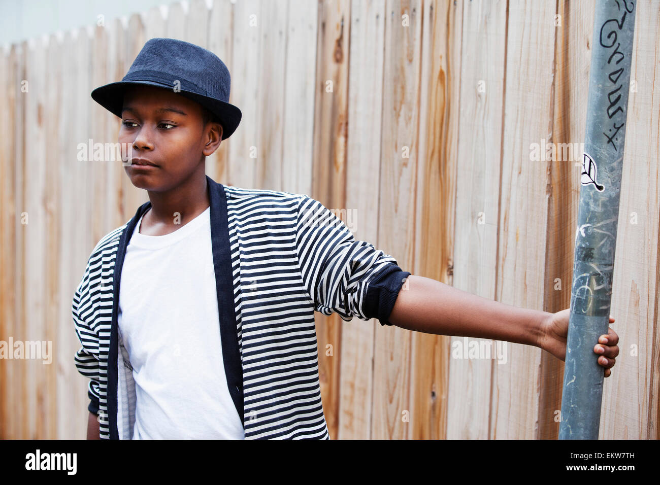 Ein junger Teenager im Fedora stehen neben einem Holzzaun; San Francisco, Kalifornien, USA Stockfoto