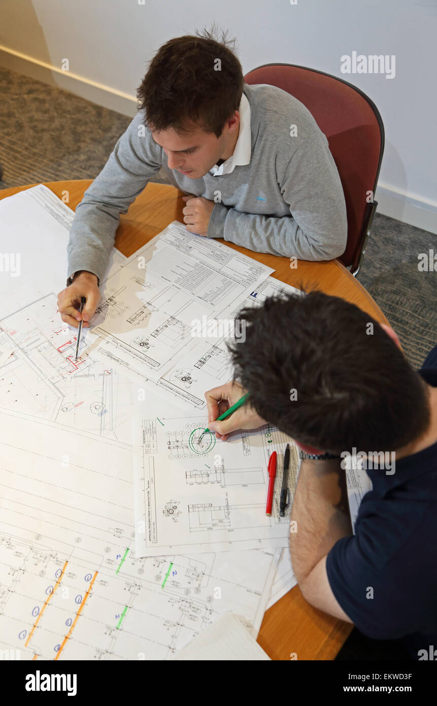 Zwei junge Ingenieure diskutieren und Konstruktionszeichnungen sitzen auf einer Tagung zu ändern Salontisch. Grobe Sicht. Stockfoto