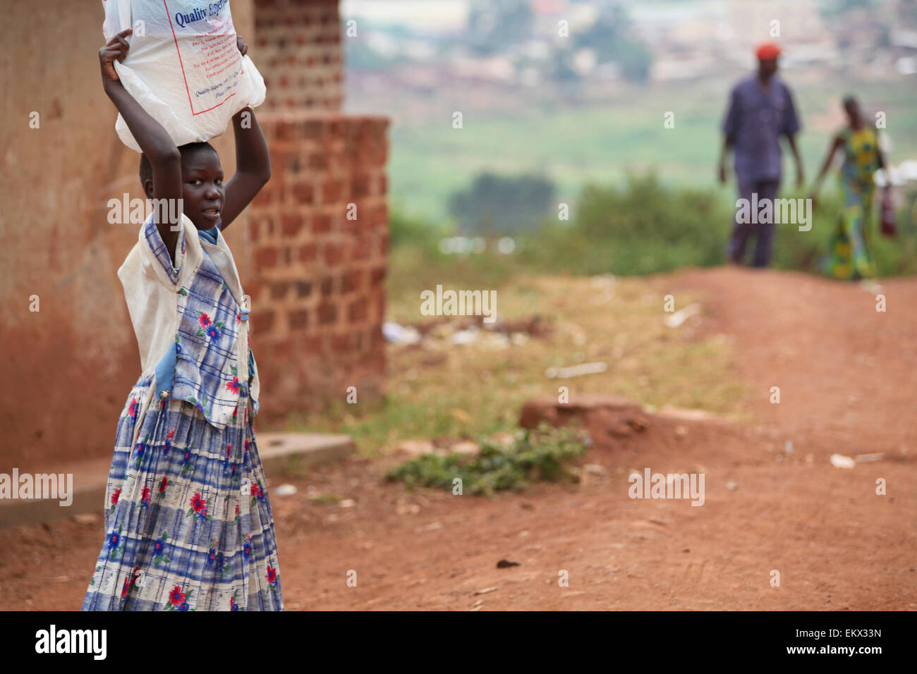 Eine junge Frau trägt eine Tasche auf dem Kopf; Kampala-Uganda-Afrika Stockfoto