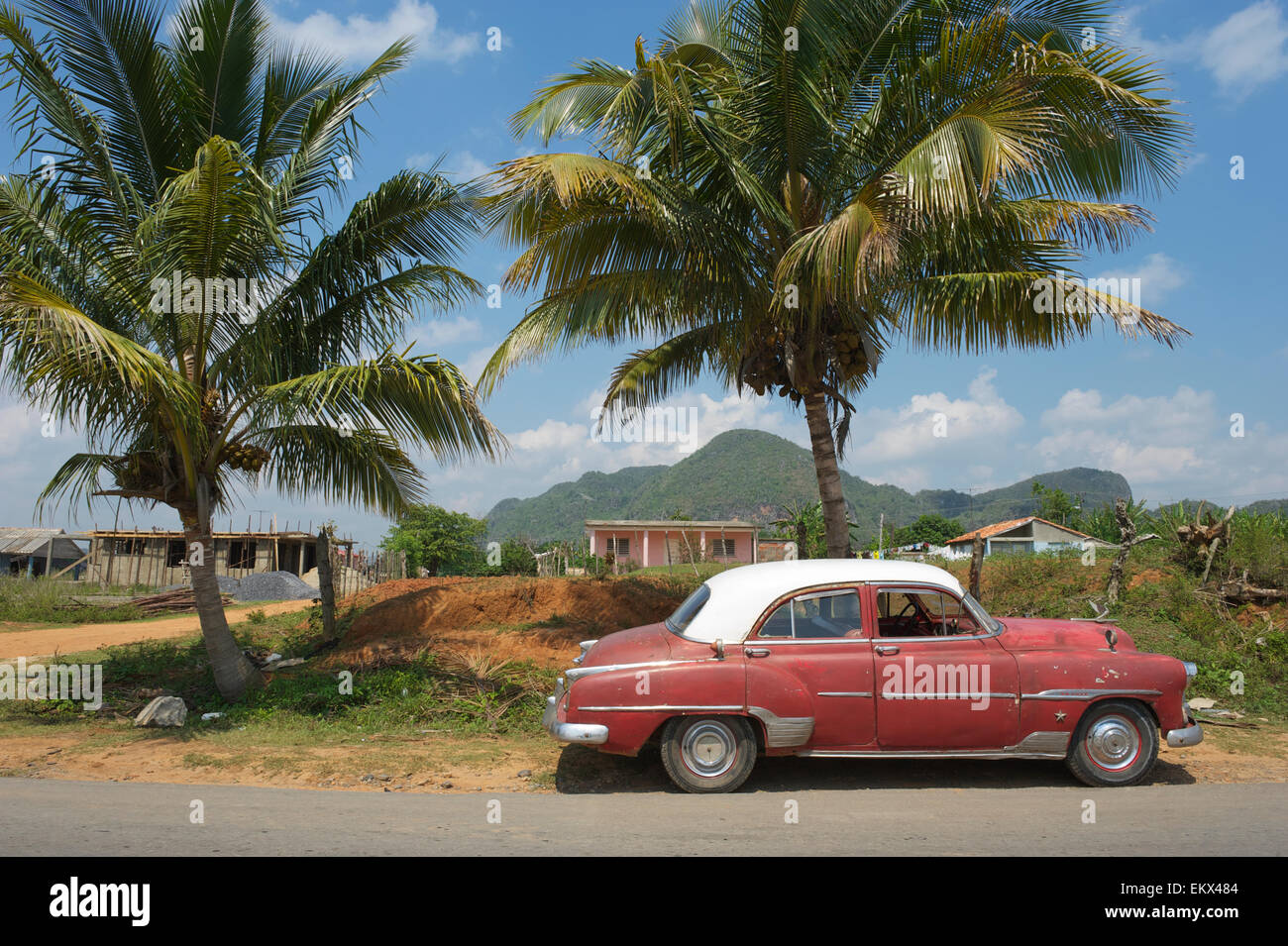 Amerikanische Oldtimer befindet sich in einer ruhigen Straße vor Palmen über einen Blick auf die nahen Berge stehen Stockfoto