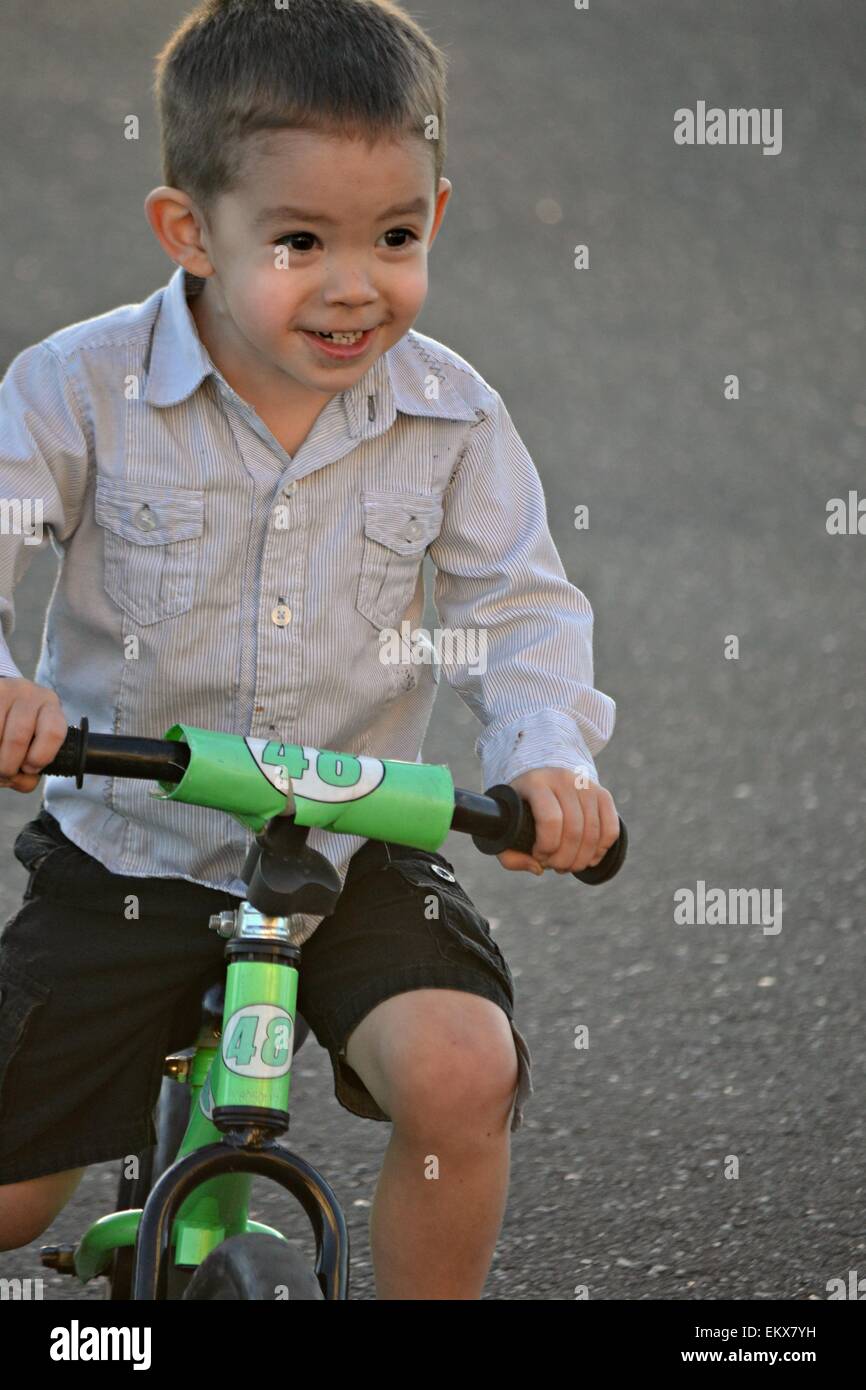 Glücklich lächelnd 3 jährigen Jungen sein Strider Fahrrad. Stockfoto
