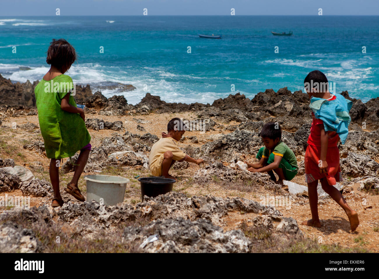 Eine Gruppe von Kindern auf trockenem, felsigen Küstengelände in Pero, Pero Batang, Kodi, Southwest Sumba, East Nusa Tenggara, Indonesien. Stockfoto