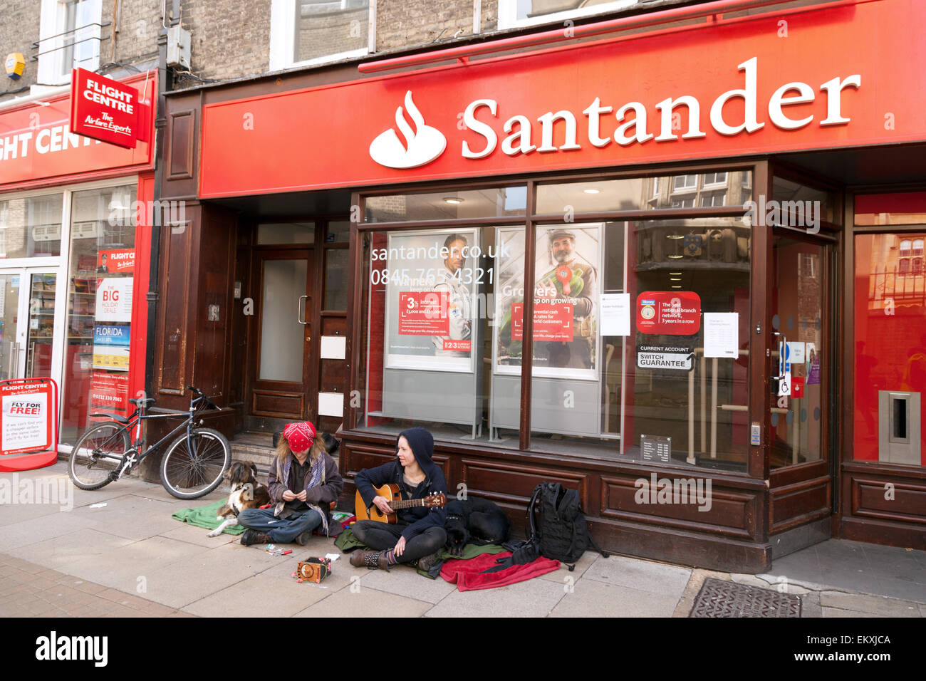 Straßenkünstler Straßenmusiker außerhalb der Santander Bank, ein Beispiel für das Konzept von Arm und reich, Sidney Street, Cambridge UK Stockfoto