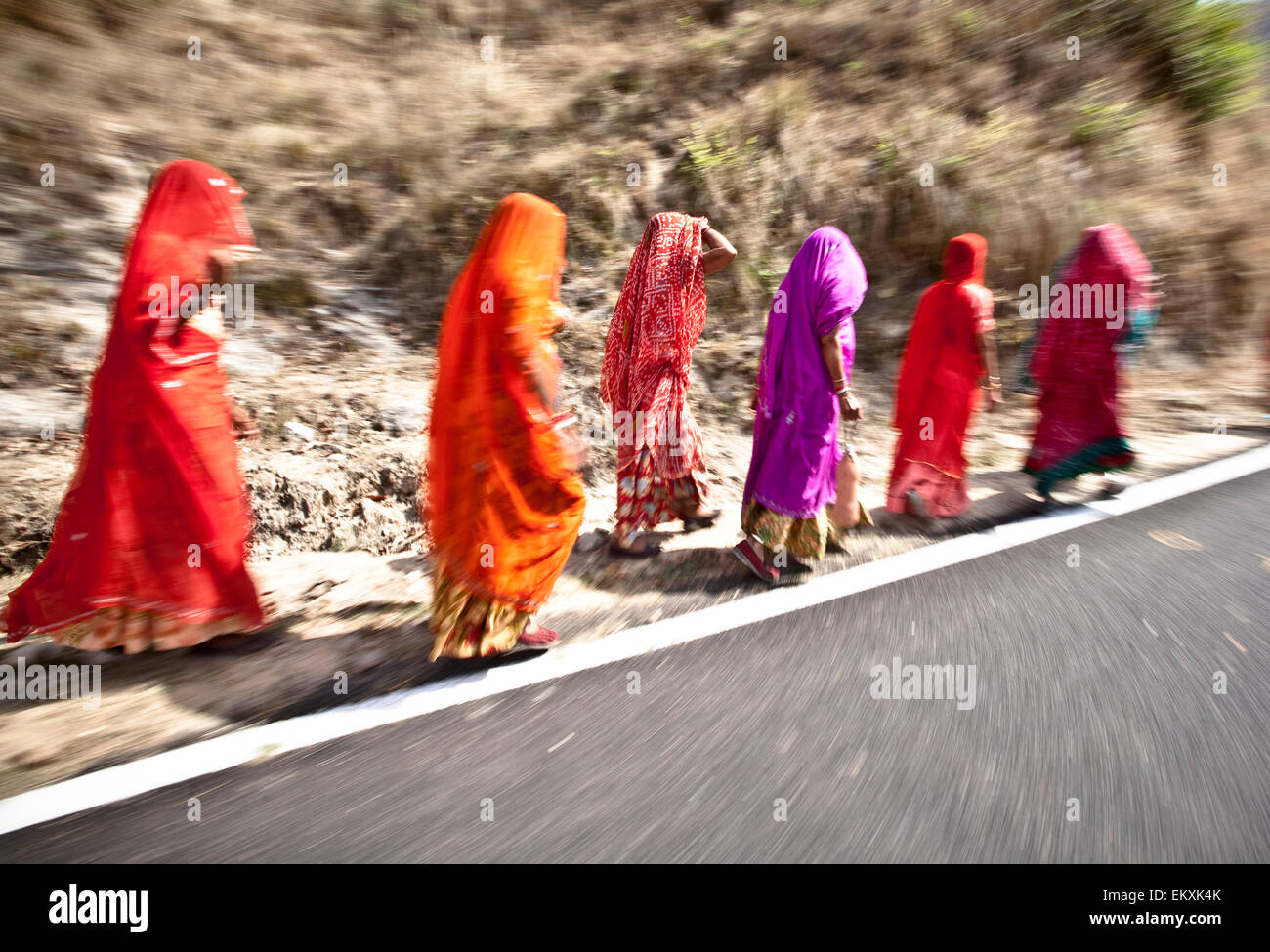 Frauen tragen Saris und Kopf-Bedeckungen Fuß entlang der Seite der Straße; Haridwar, Indien Stockfoto