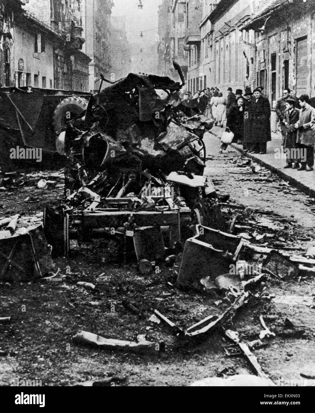 Ungarischen Aufstand 1956. Schaulustige inspizieren den Wirren Trümmern eines unbekannten Fahrzeugs nach schweren Straßenkämpfen in der Innenstadt von Budapest am 4. November 1956 zwischen ungarischen Freiheitskämpfer und der sowjetischen Armee. Stockfoto