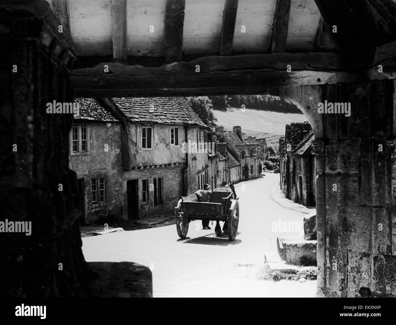 Pferd gezeichneten Wagen macht seinen Weg nach unten eine typische Cotswold Dorfstraße in Gloucestershire. Ca. 1935. Stockfoto