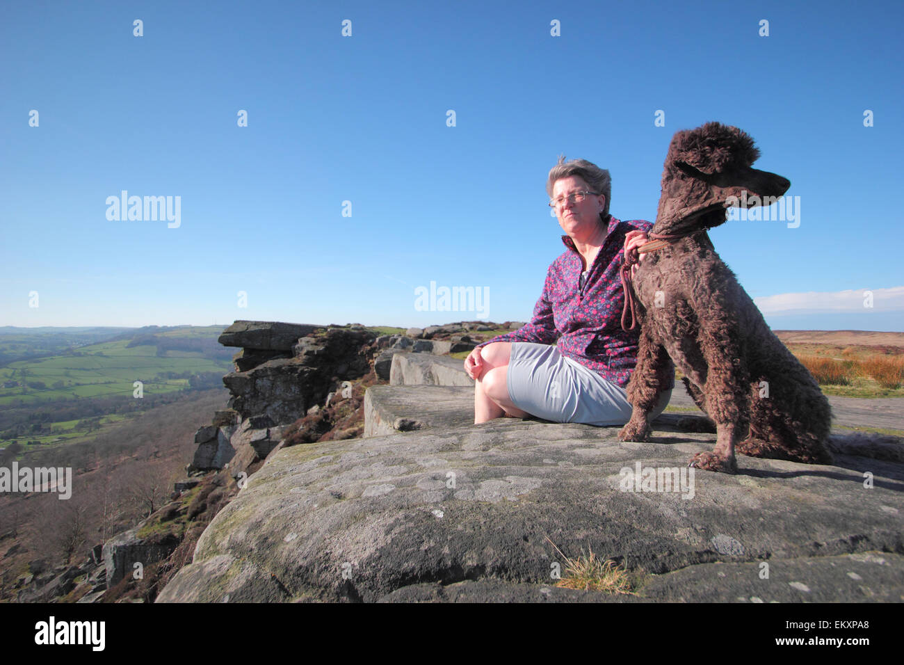 Peak District, Derbyshire, UK. 14. April 2015. Archie der standard Pudel und seinem Besitzer Katie France aus Chesterfield, Derbyshire geniessen Sie die Aussicht über das Derwent Tal von Curbar Kante an einem warmen, luftigen Nachmittag im Peak District. Bildnachweis: Matthew Taylor/Alamy Live-Nachrichten Stockfoto