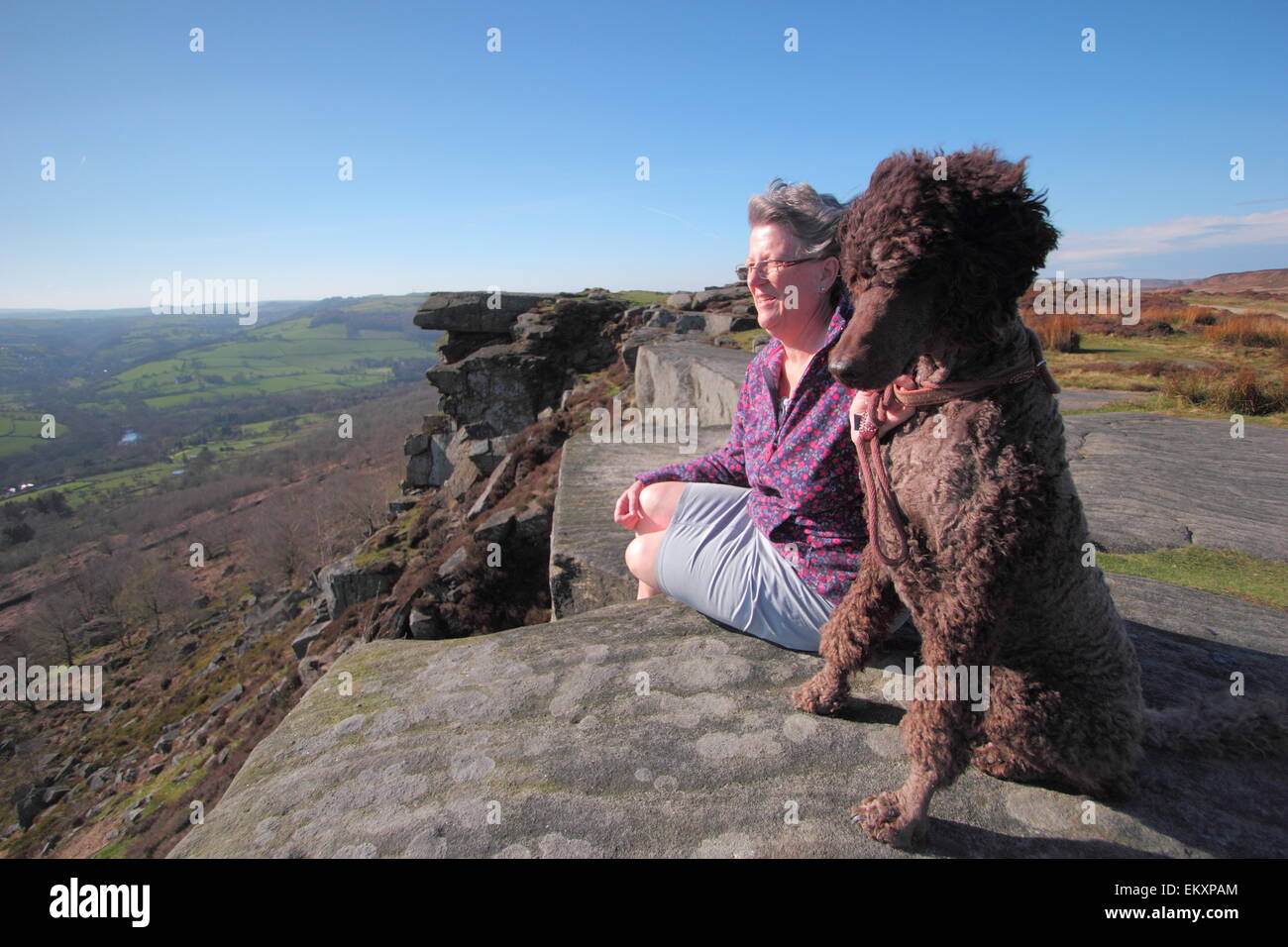 Peak District, Derbyshire, UK. 14. April 2015. Archie der standard Pudel und seinem Besitzer Katie France aus Chesterfield, Derbyshire geniessen Sie die Aussicht über das Derwent Tal von Curbar Kante an einem warmen, luftigen Nachmittag im Peak District. Bildnachweis: Matthew Taylor/Alamy Live-Nachrichten Stockfoto