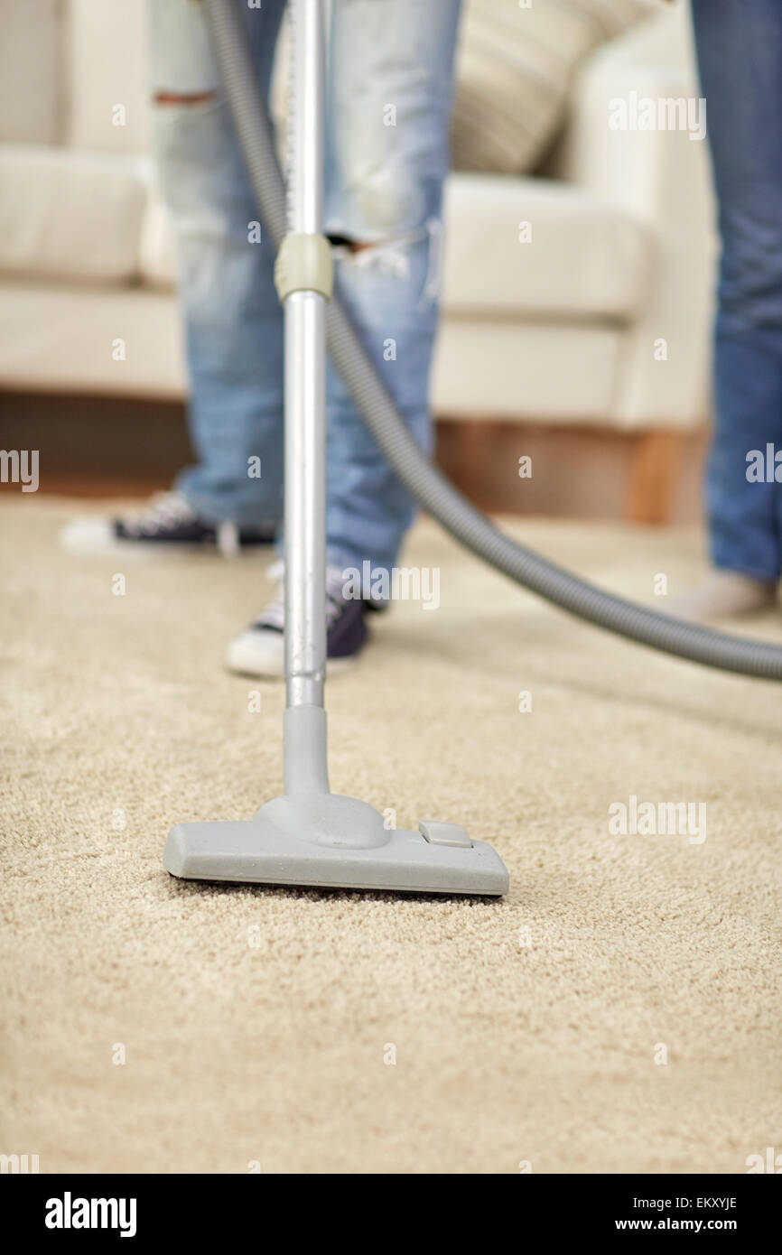 Nahaufnahme eines menschlichen Beinen und Staubsauger zu Hause Stockfoto