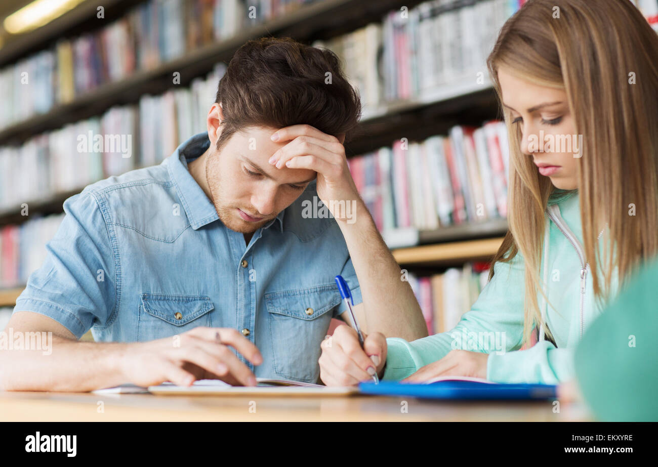 Studenten schreiben in Notebooks in der Bibliothek Stockfoto