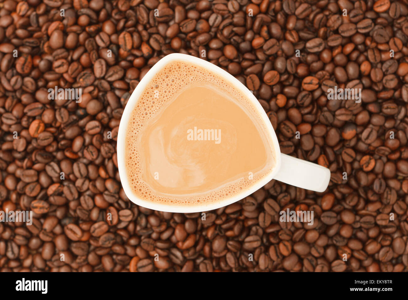 Tasse Kaffee mit Milch auf Kaffeebohnen Hintergrund Stockfoto