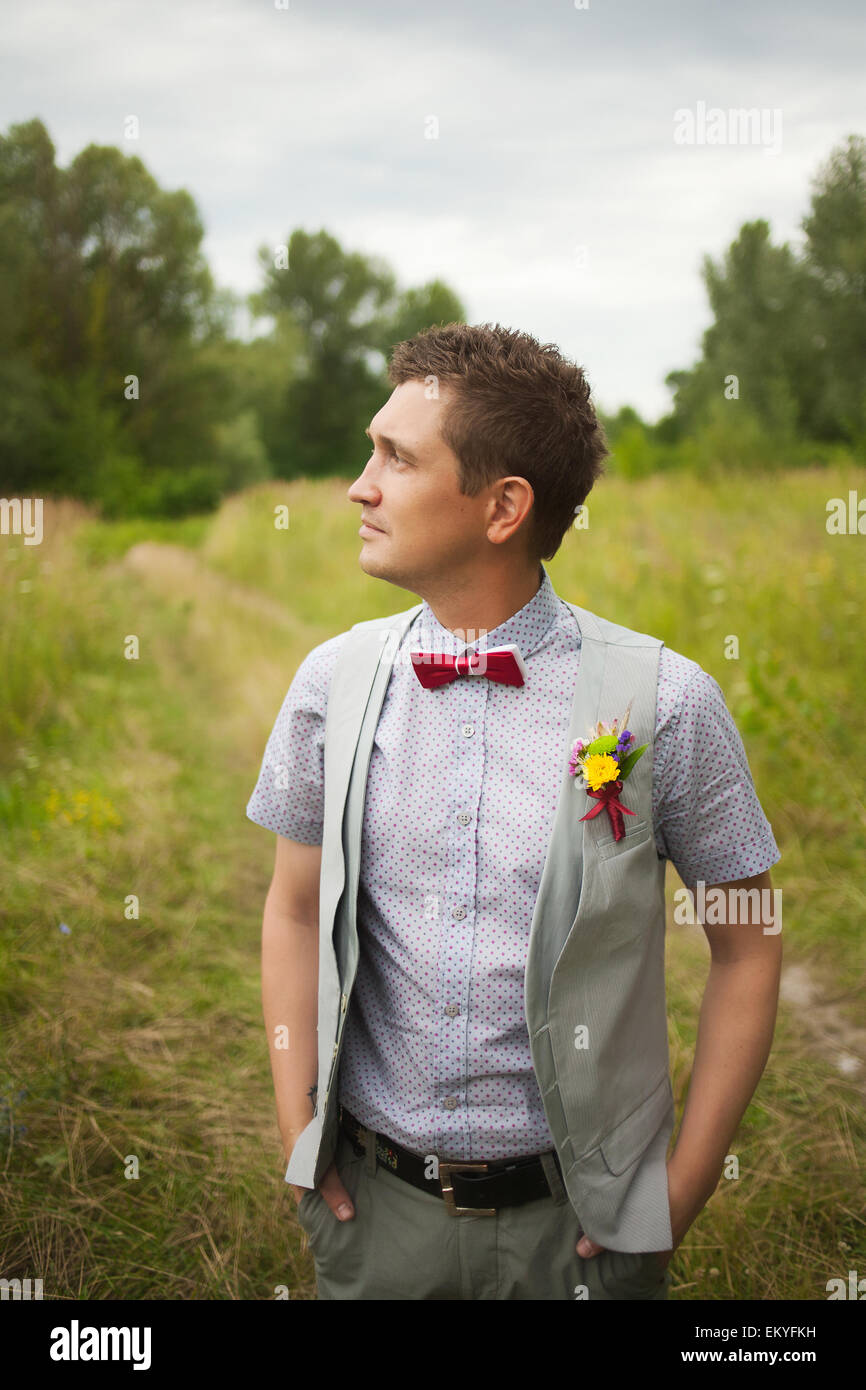 Porträt von gut aussehenden jungen Mann elegant gekleidet. Boutonniere. Rote Schleife. Stilvolle person Stockfoto
