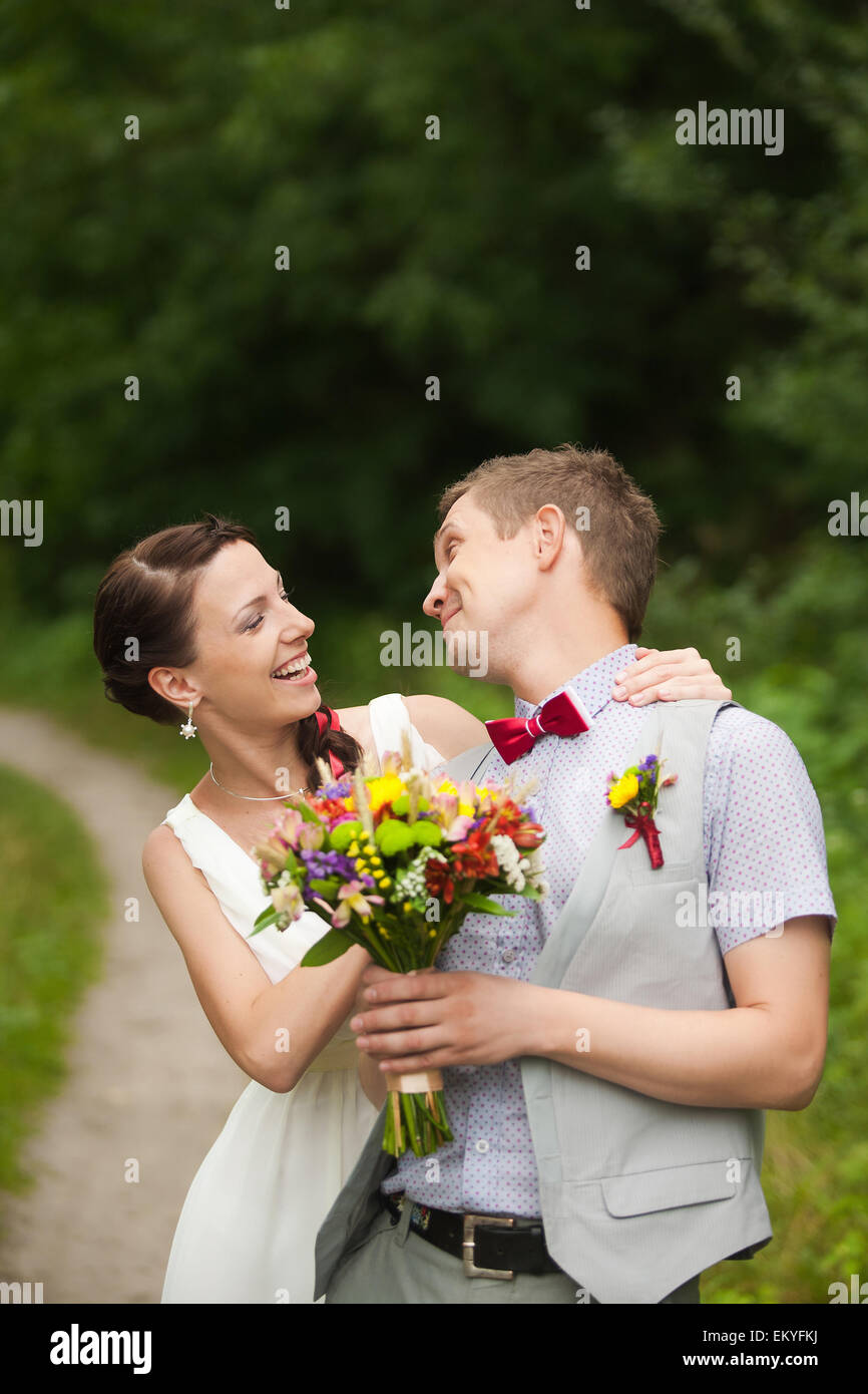 glückliche Braut, Bräutigam stehen im grünen Park, küssen, Lächeln, lachen, umarmen. Liebhaber in Hochzeitstag Stockfoto