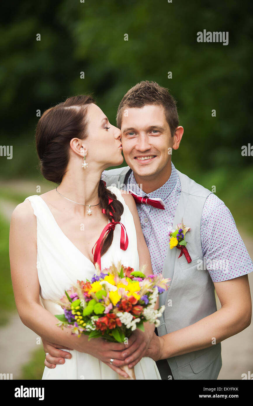 glückliche Braut, Bräutigam stehen im grünen Park, küssen, Lächeln, lachen, umarmen. Liebhaber in Hochzeitstag Stockfoto