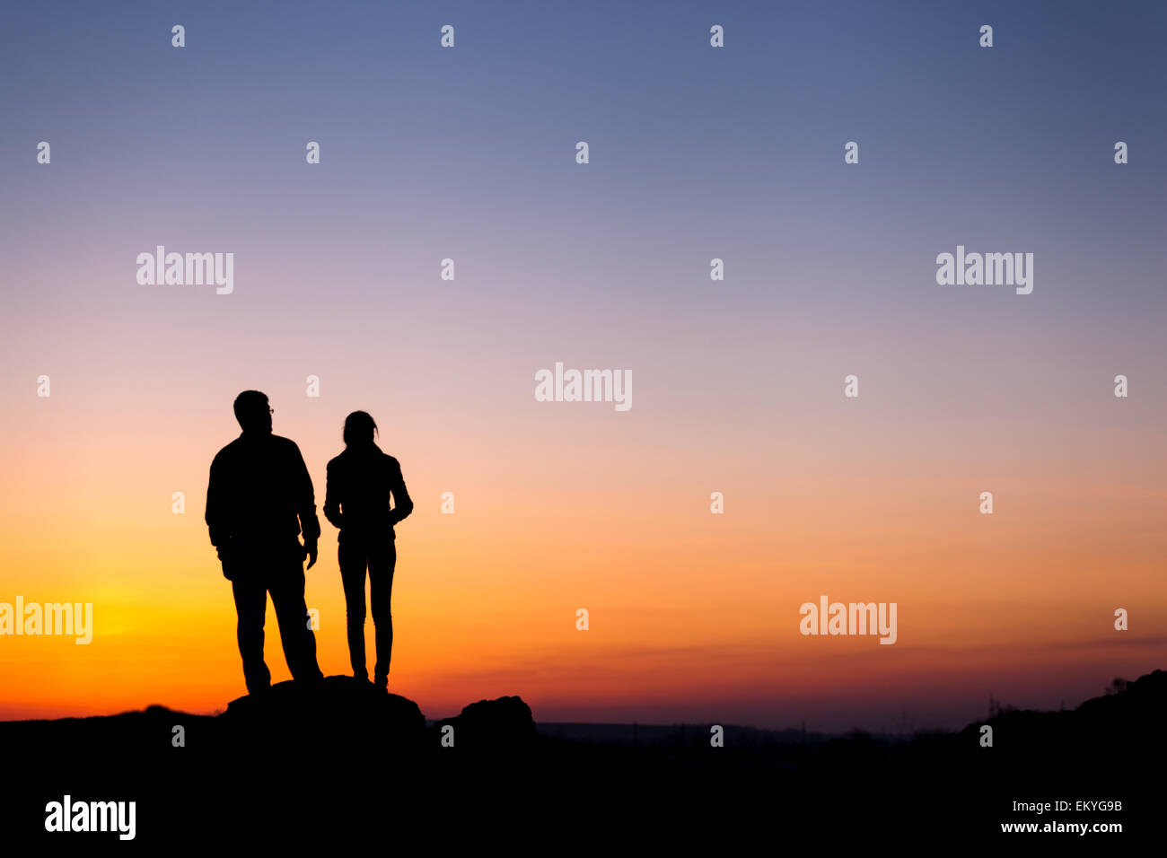 Silhouette von Glück Familie gegen die schönen bunten Himmel. Sommer Sonnenuntergang. Landschaft Stockfoto