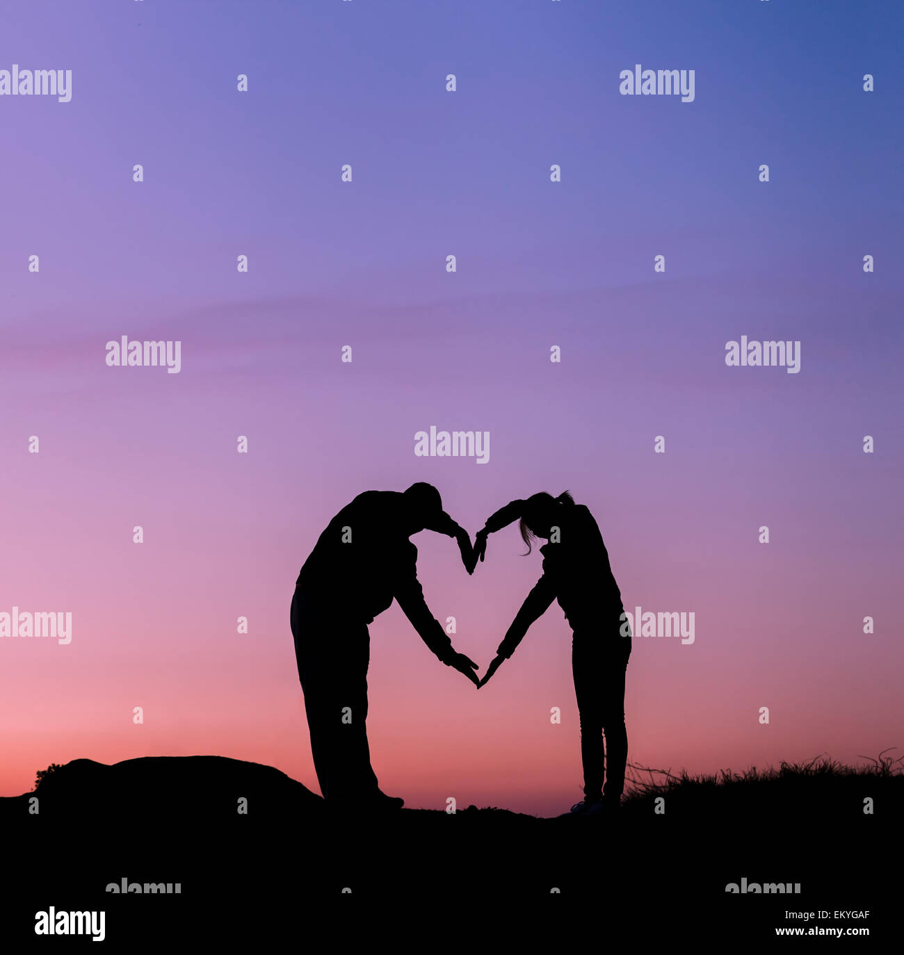 Konzeptionelle Herzform, Symbol des Menschen. Frau und Mann übergeben Silhouette Himmel bei Sonnenuntergang Hintergrund, Metapher, zu lieben, valentin Stockfoto