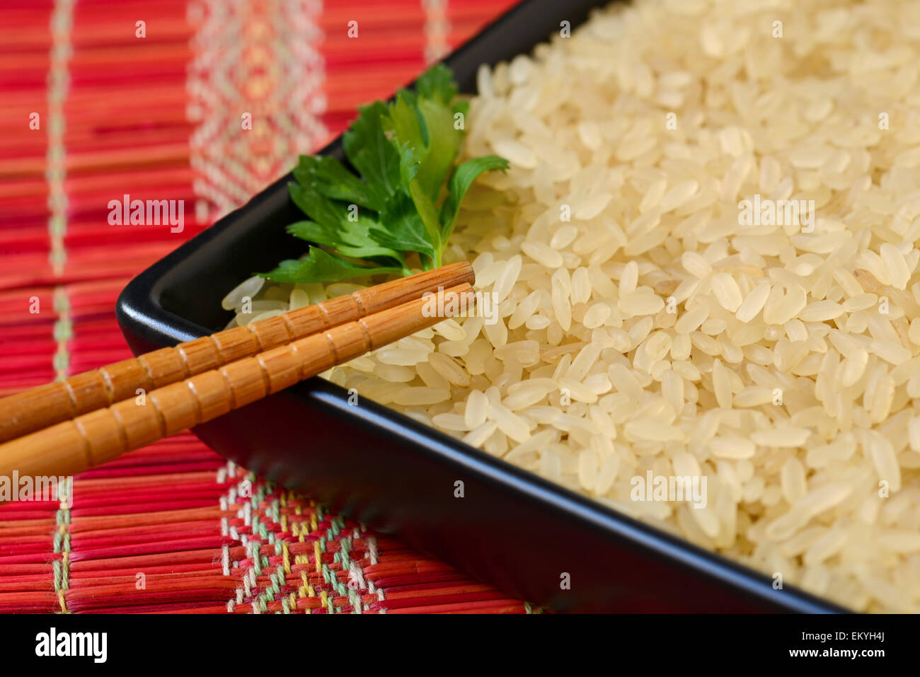 Platte mit braunen ungekochtem Reis und Blatt Petersilie Stockfoto