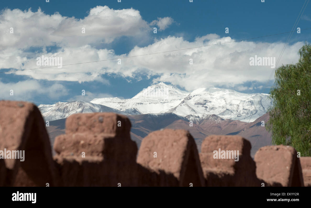 Andengipfel gesehen jenseits einer Lehmziegeln Mauer bei San Pedro de Atacama, Chile Stockfoto