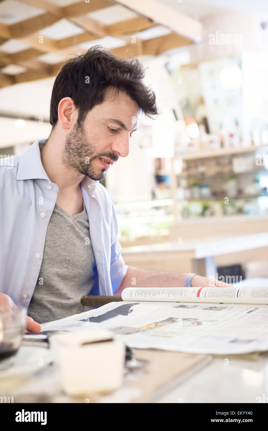 Mann an der Bar lesen Zeitung Stockfoto