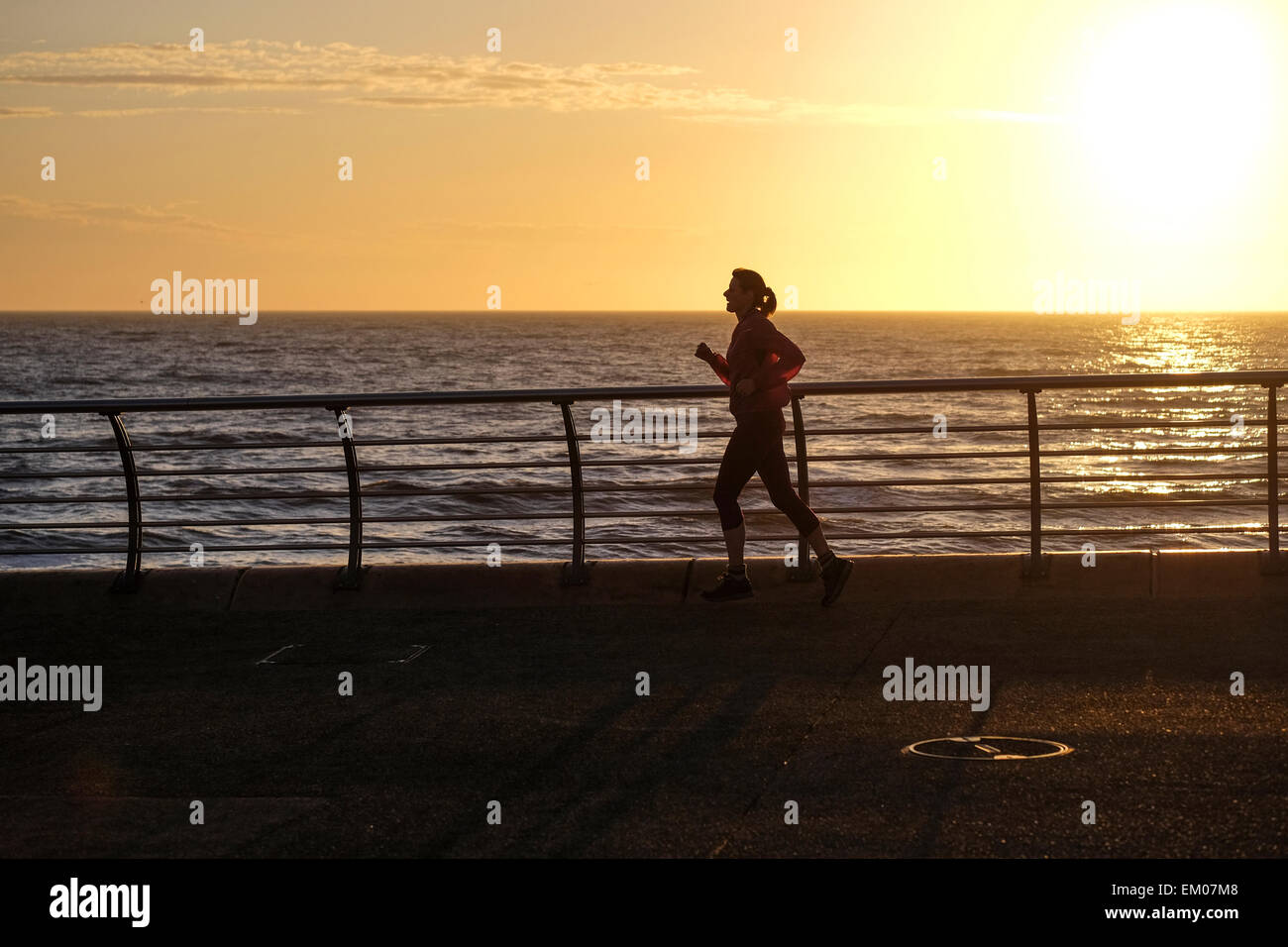 Blackpool, UK: Frauen Joggen entlang der Promenade in Blackpool beim Sonnenuntergang an der Küste von Fylde Stockfoto
