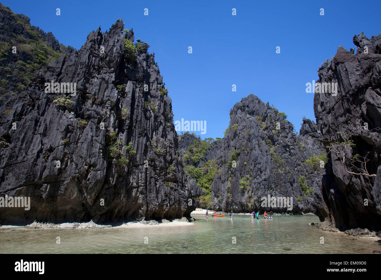 Touristen waten In die kleine Lagune auf Miniloc Island, in der Nähe von El Nido; Bacuit Archipel, Palawan, Philippinen Stockfoto