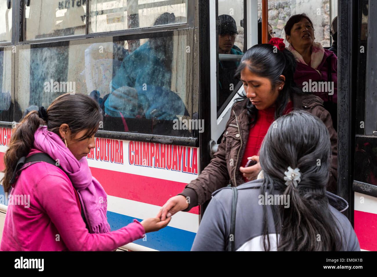 Peru, Cusco.  Frau in rosa Tarif von Bus-Fahrgast aussteigen zu sammeln. Stockfoto