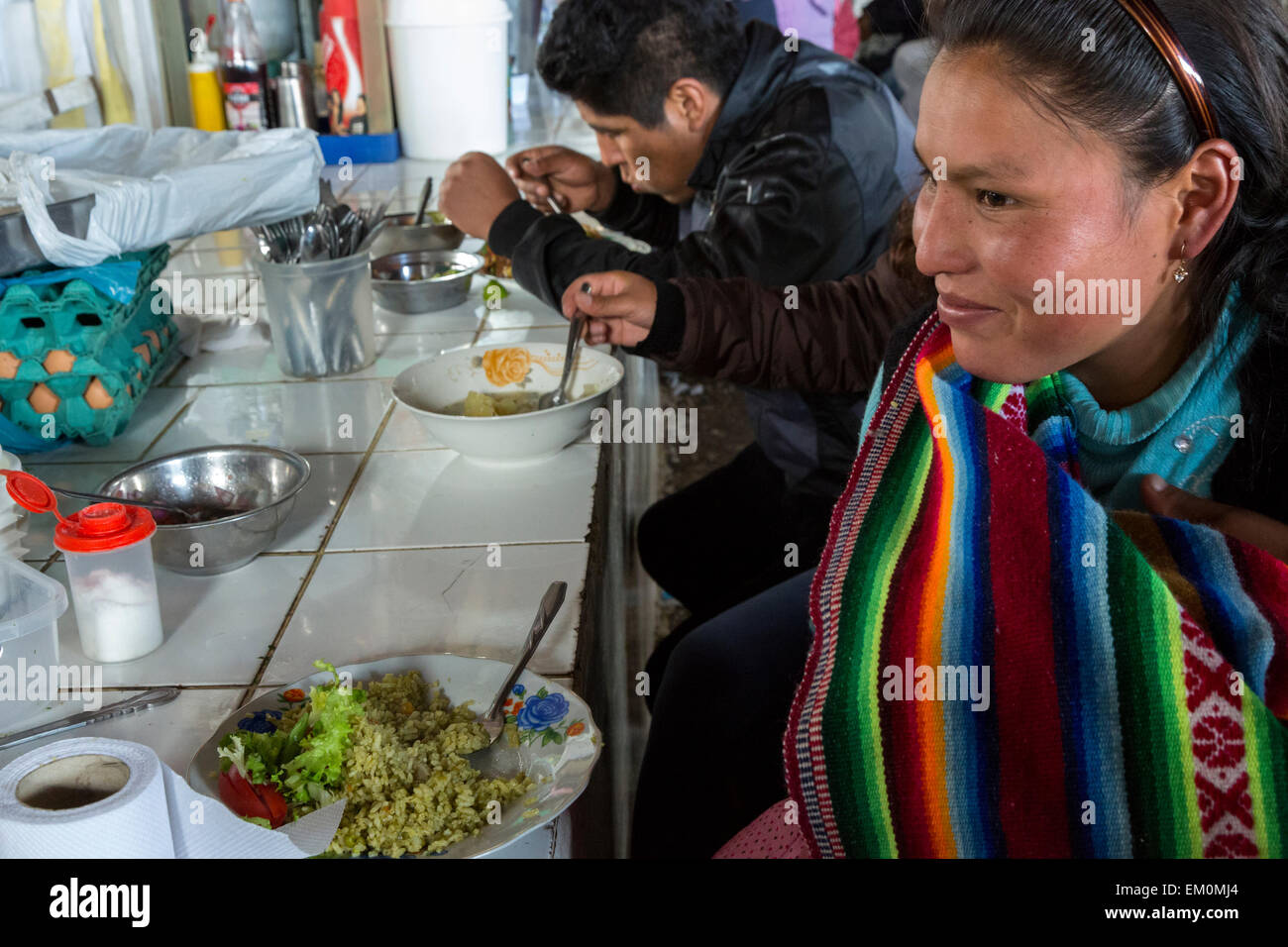 Peru, Cusco, San Pedro-Markt.  Frau beim Mittagessen an einem Bedientheke im Bereich Food-Court des Marktes. Stockfoto