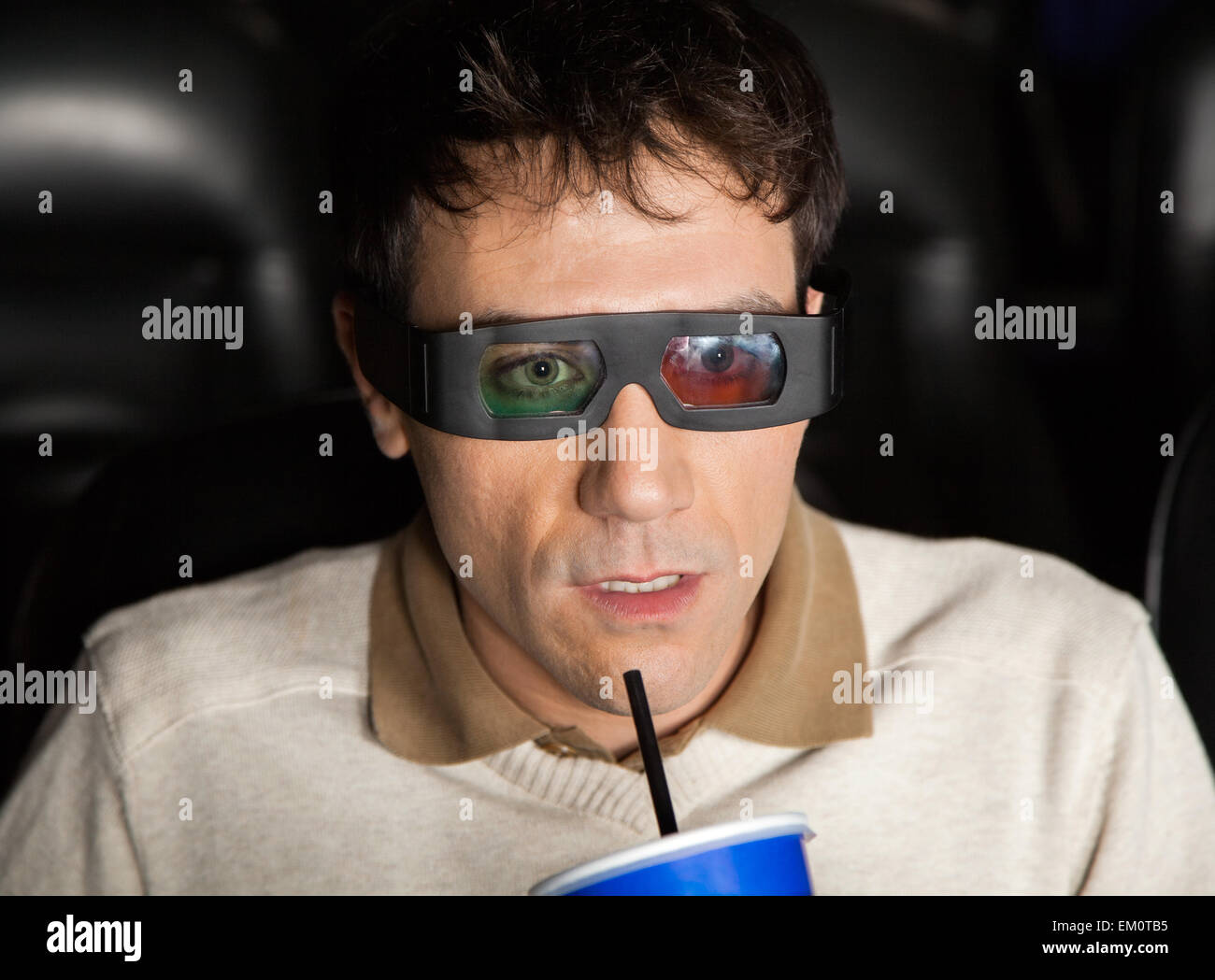 Schockiert Mann trinken Cola beim 3D Film Stockfoto