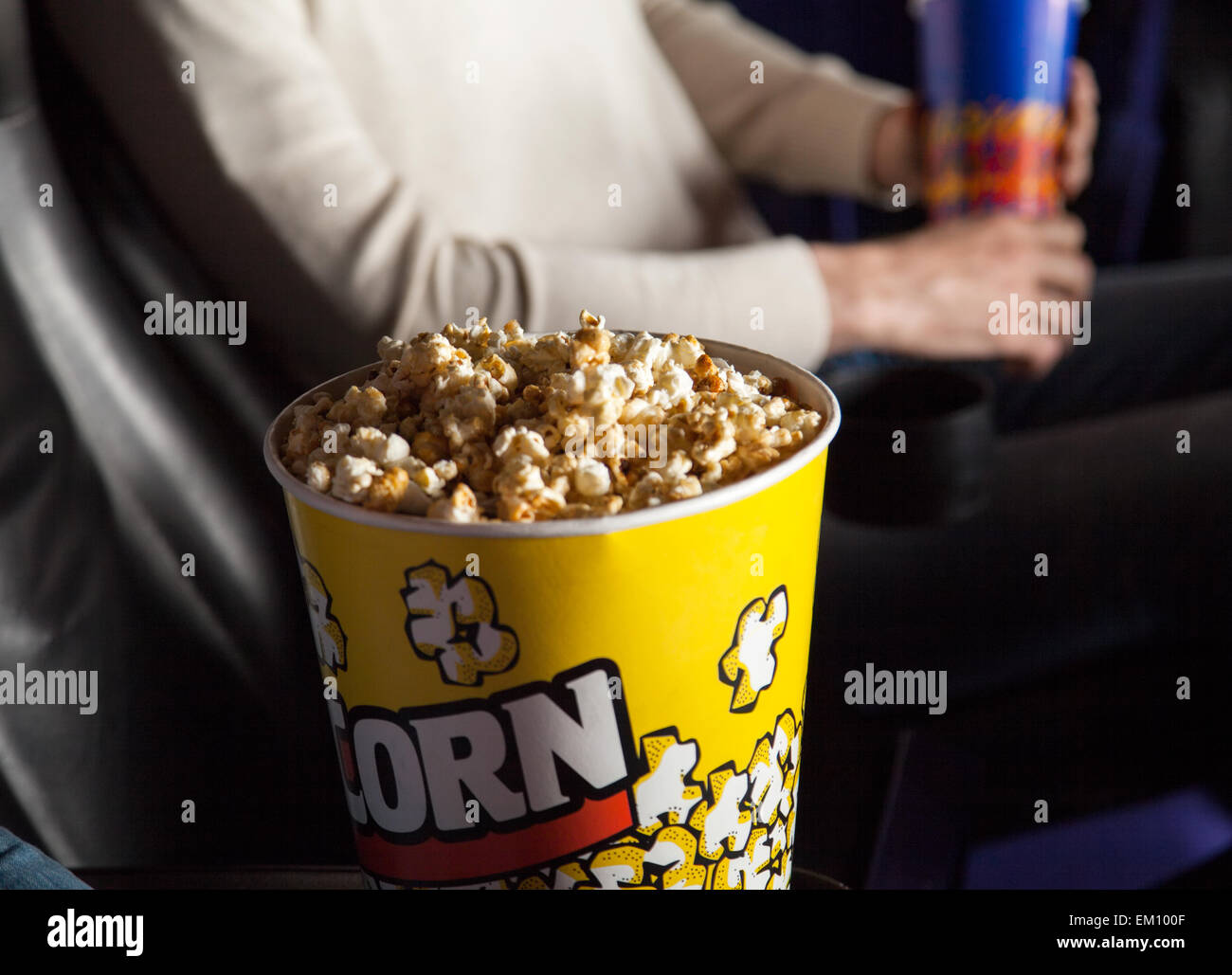 Popcorn-Eimer mit Mann sitzt im Theater Stockfoto