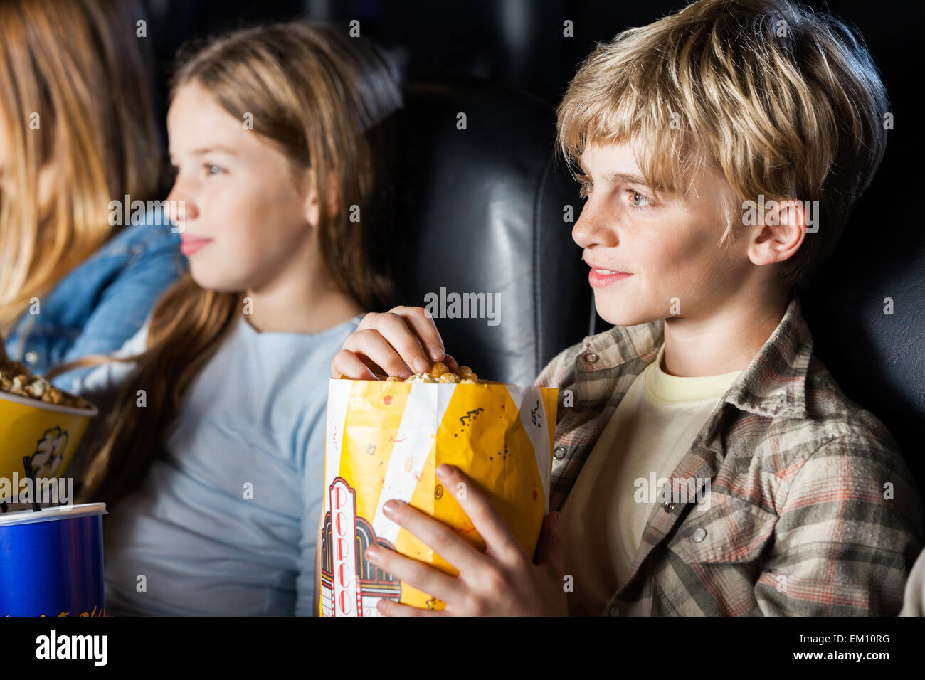 Junge Popcorn zu essen, während der Film mit der Familie Stockfoto