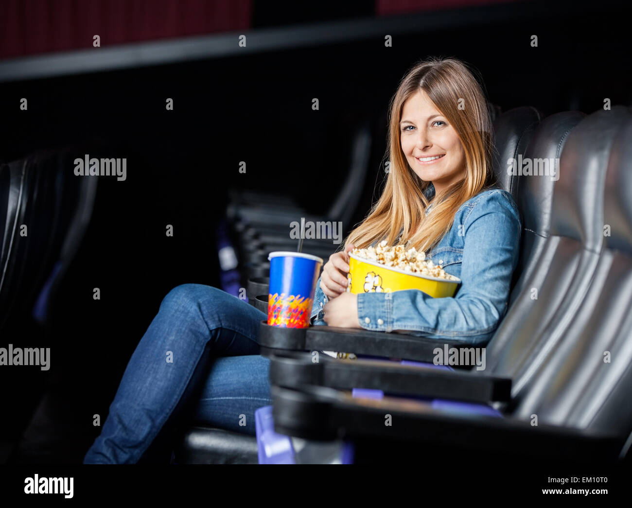 Lächelnde Frau mit Snacks im Kino-Theater Stockfoto