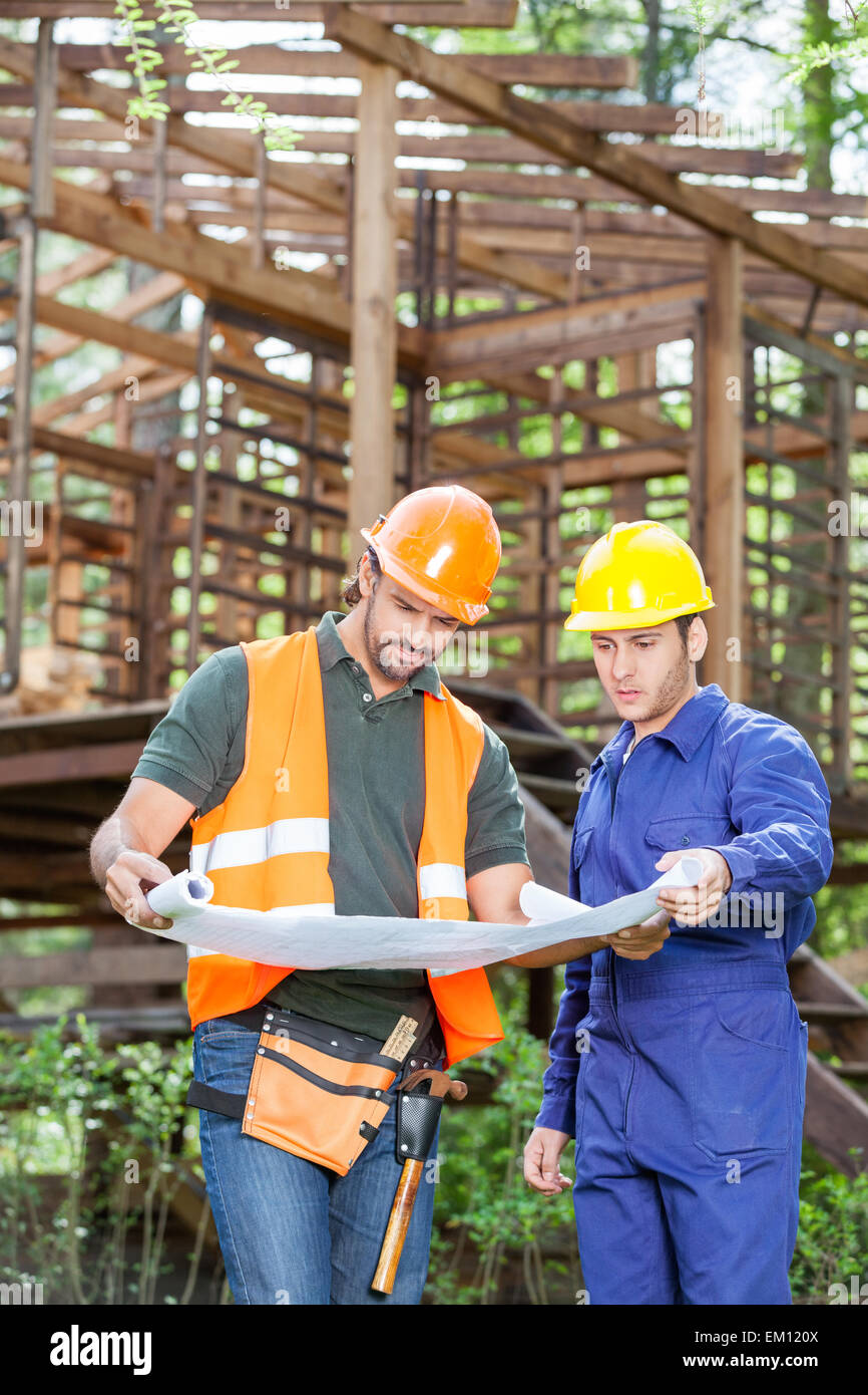 Architekten, die Blaupause außerhalb unvollständig Holzhütte zu studieren Stockfoto