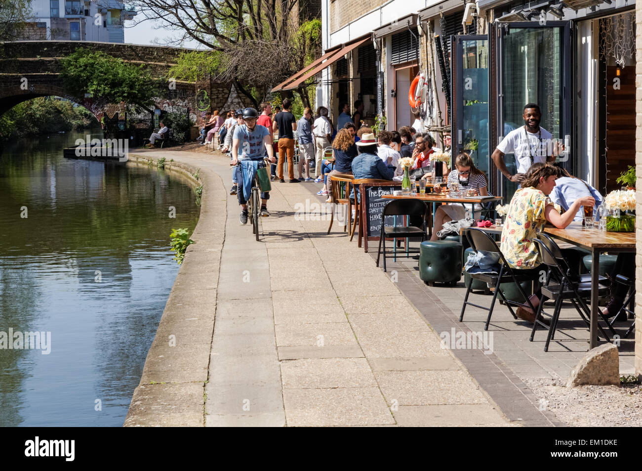 Menschen genießen schönes Frühlingswetter auf Towpath am Ufer des Regent's Canal in Hackney, London England Großbritannien Stockfoto