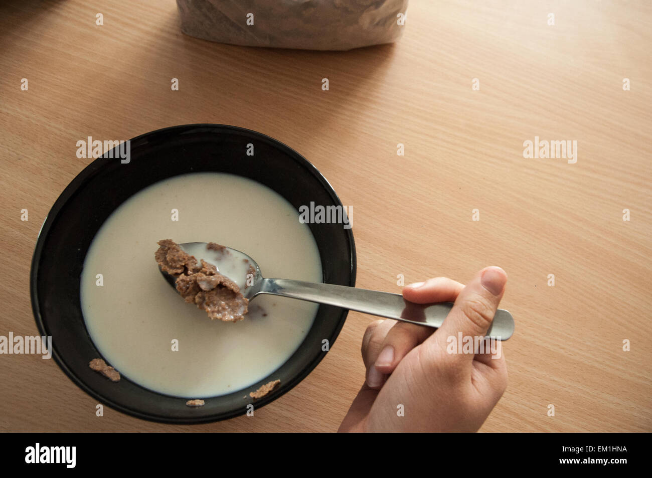 Una Persona Cogiendo Getreidearten de un-Schüssel de La Mesa de Una Cocina.  Eine Person essen Getreide in den Küchentisch Stockfoto