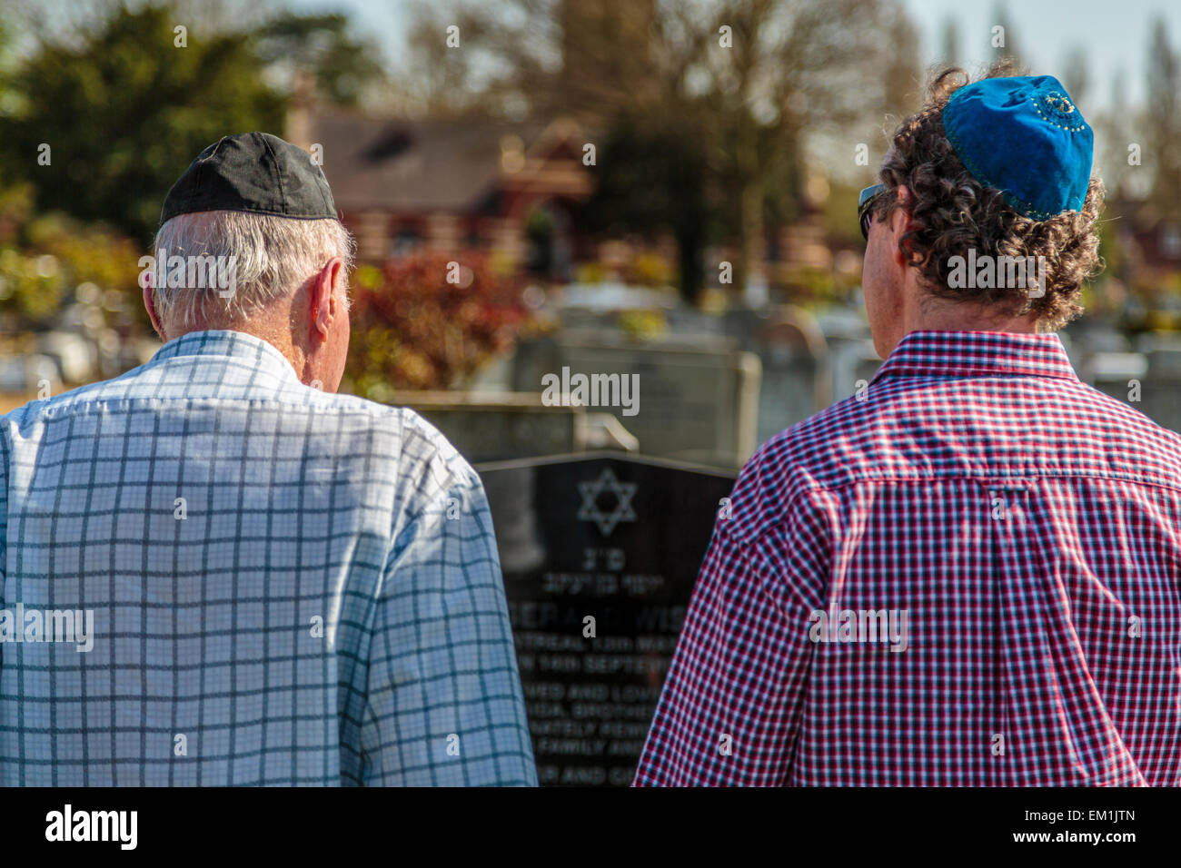 Jüdische Trauernde, die an einem heißen Sommertag in London England ihren Respekt auf einem Friedhof am Grab bekunden Stockfoto