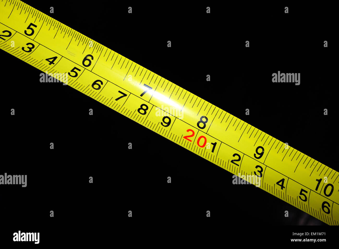 Eine gelbe Maßband statt vor einem schwarzen Hintergrund. Stockfoto