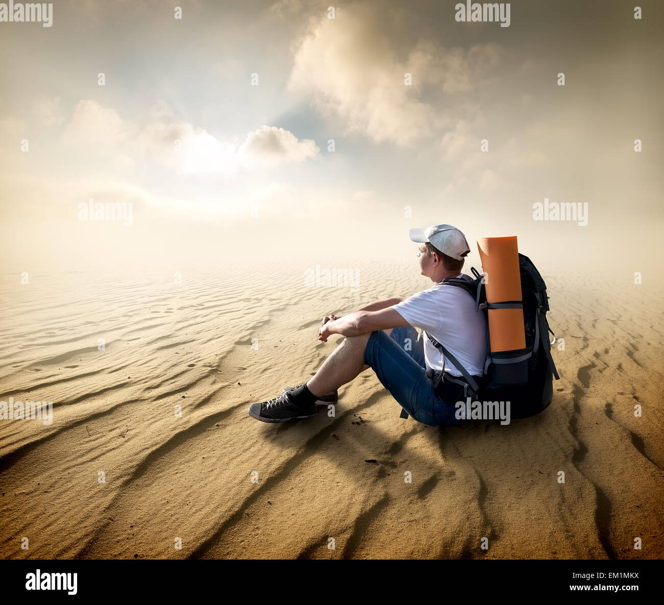 Touristen sitzen in einer Sandwüste und Blick auf Sonne Stockfoto