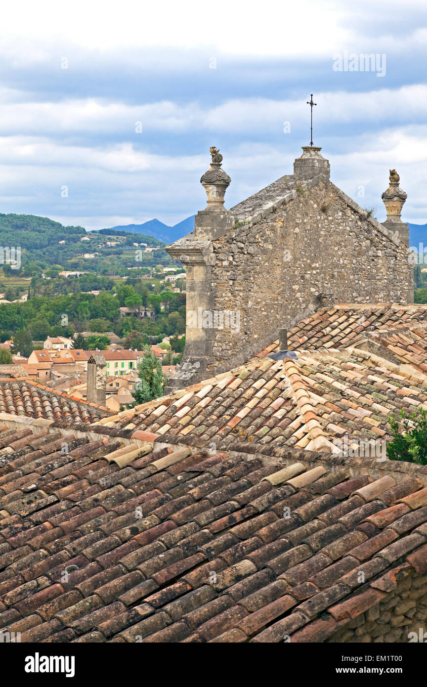 Ziegeldächer und eine Fassade der Kirche umrahmen die provenzalische Landschaft aus Oberstadt Vaison-la-Romaine. Provence, Frankreich. Stockfoto