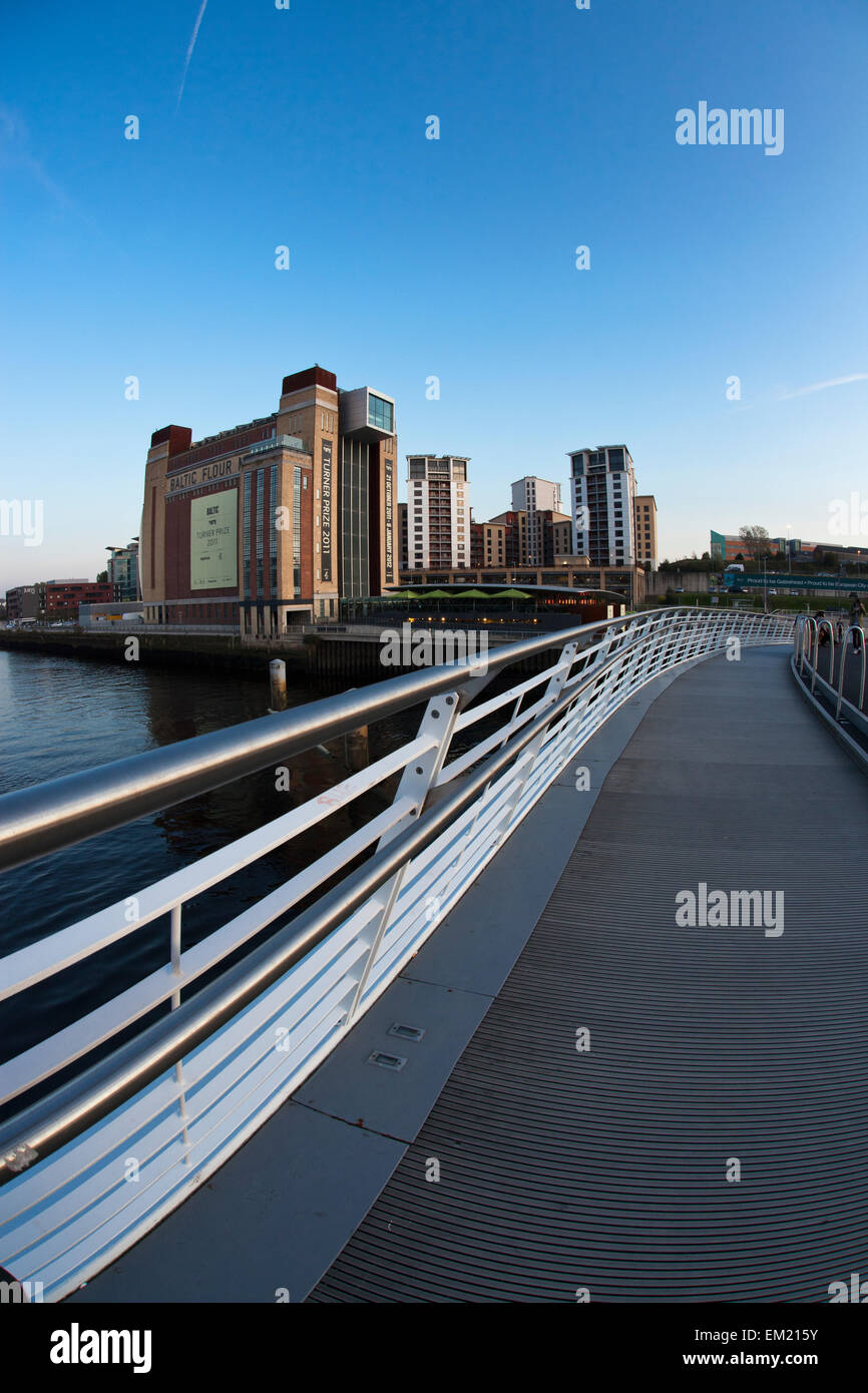 Eine Brücke zu Fuß über einen Fluss mit Tall Buildings In der Ferne; Gateshead Tyne And Wear, England Stockfoto