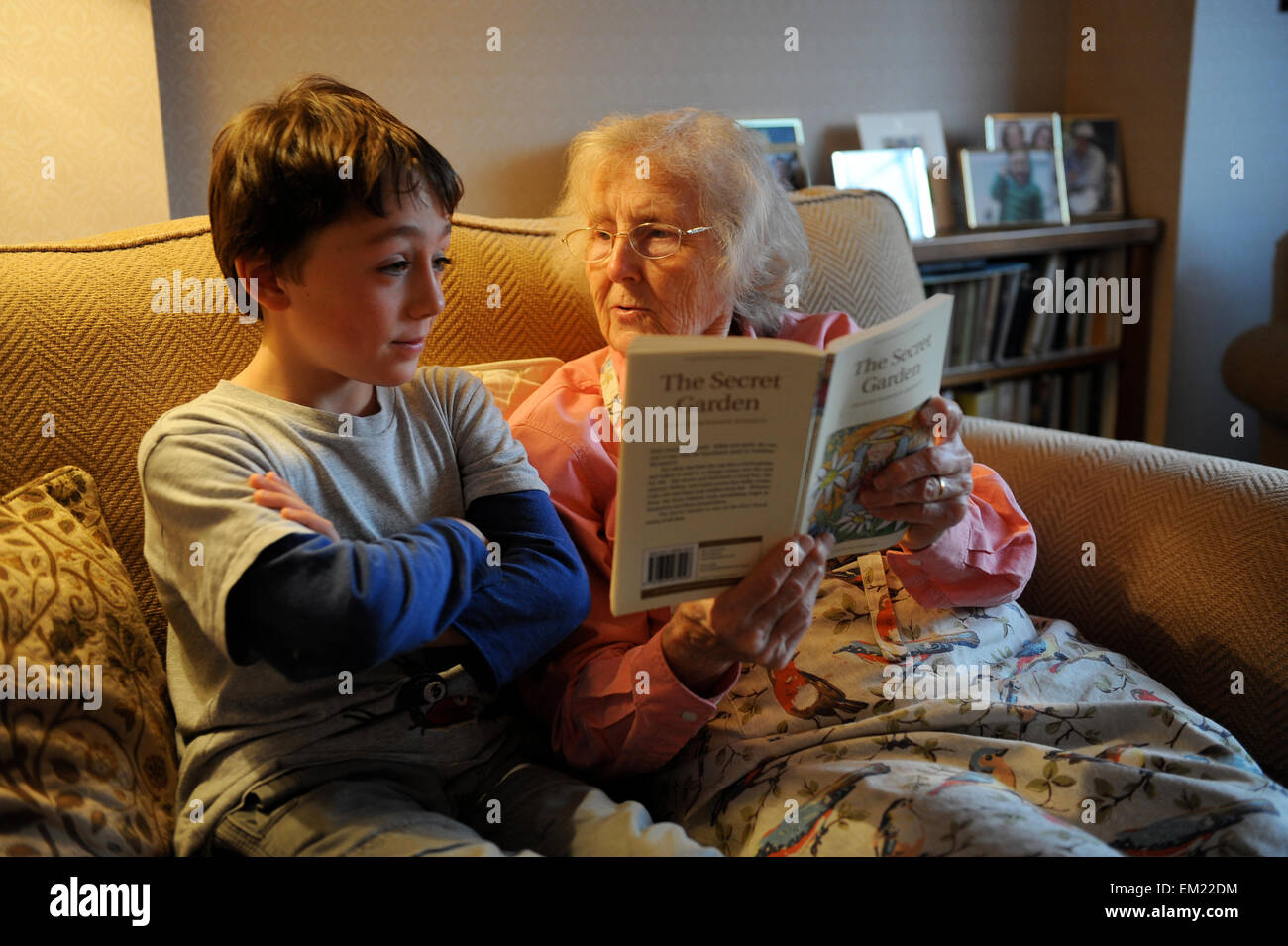Großeltern hören von ihrem Enkel Lesen der Geheimgarten Stockfoto