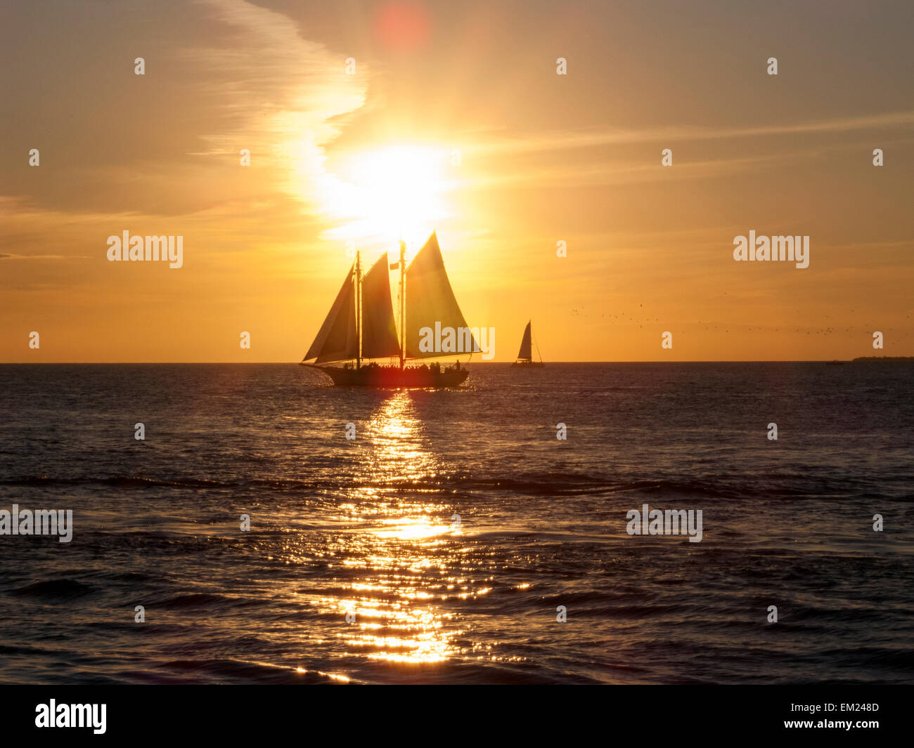 Segelboot mit Touristen am Mallory Square während der tägliche Sonnenuntergang Feier, Key West, Florida. Stockfoto