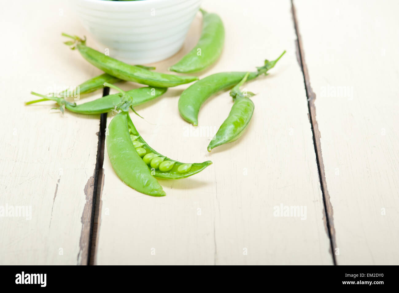 hearthy frische grüne Erbsen über einen rustikalen Holztisch Stockfoto