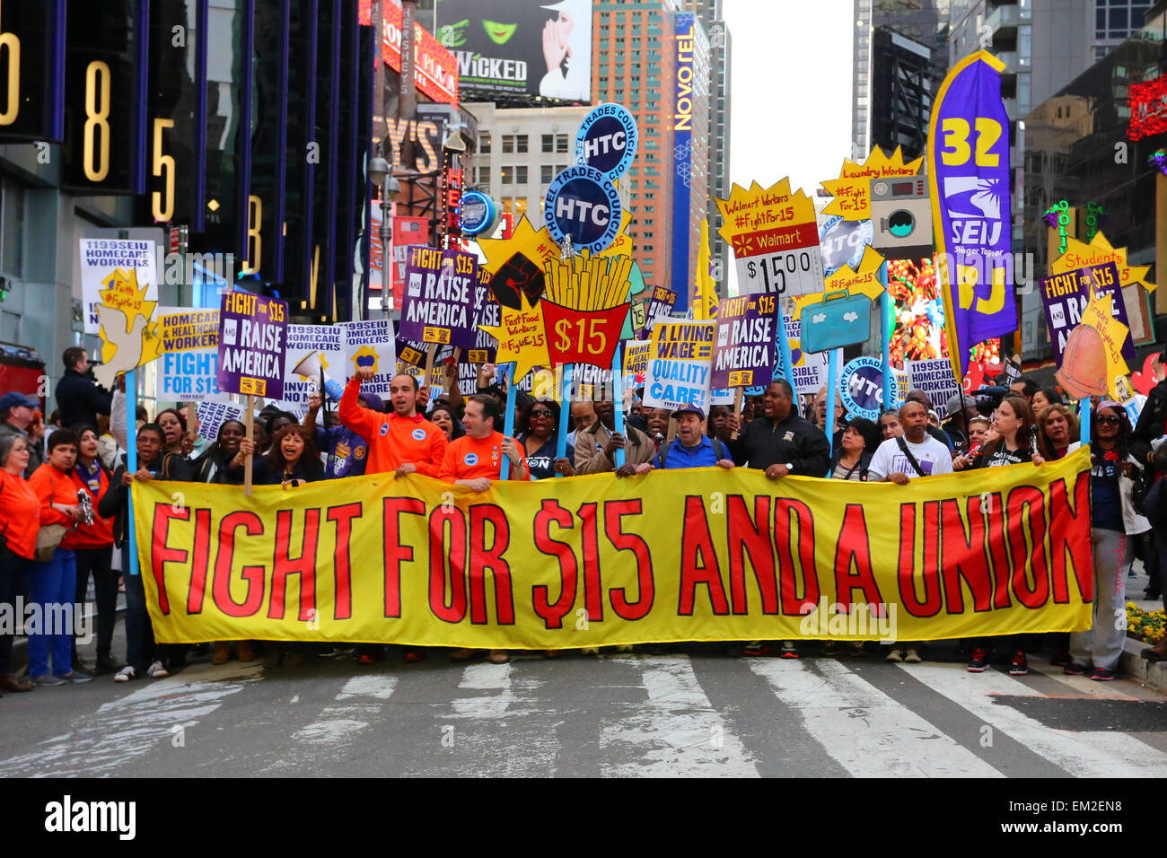 Aktivisten auf dem Times Square entfalten ein großes Banner "Kampf für $15 und A Union" Stockfoto